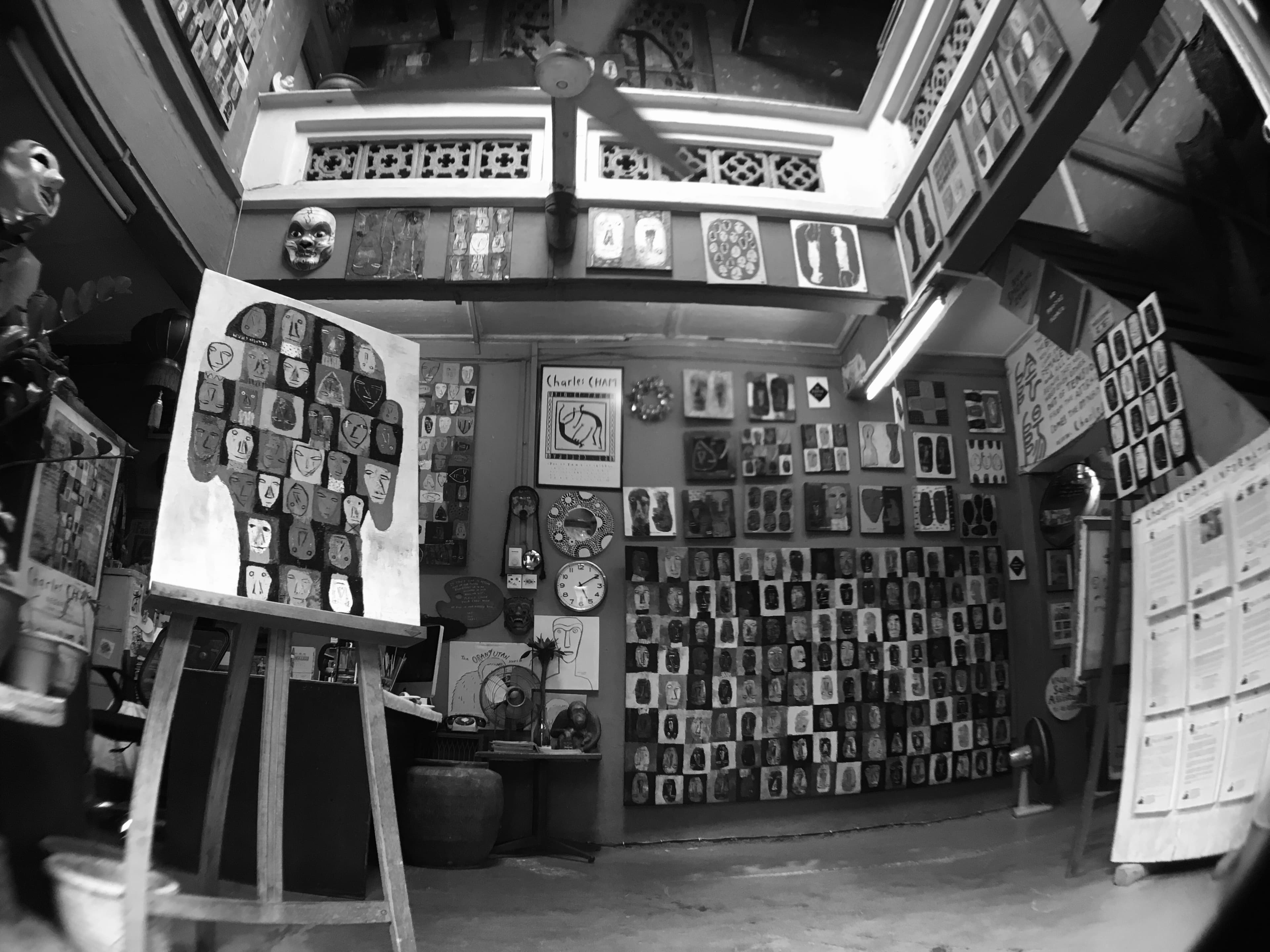 Charles Cham's studio in Melaka, walls covered with painted mask-like faces